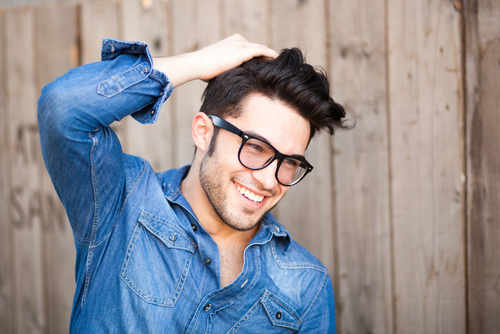 Man with glasses rubbing hair 