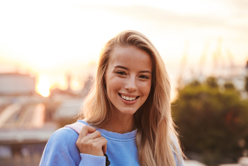 smiling woman with sunset in the background