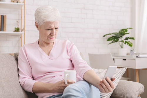 woman using cell phone on couch 