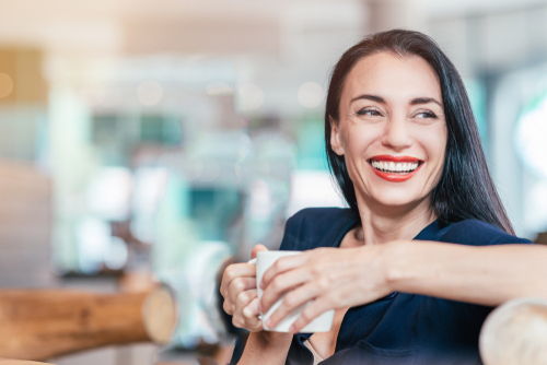 woman smiling holding coffee cup 