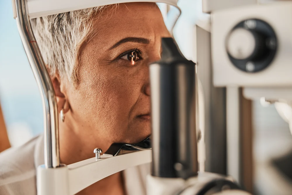 Senior woman having her eyes tested using a machine at ophthalmologist