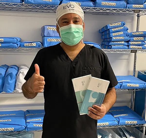 Dr. Mateen holding EVO ICL packages and giving a thumbs up