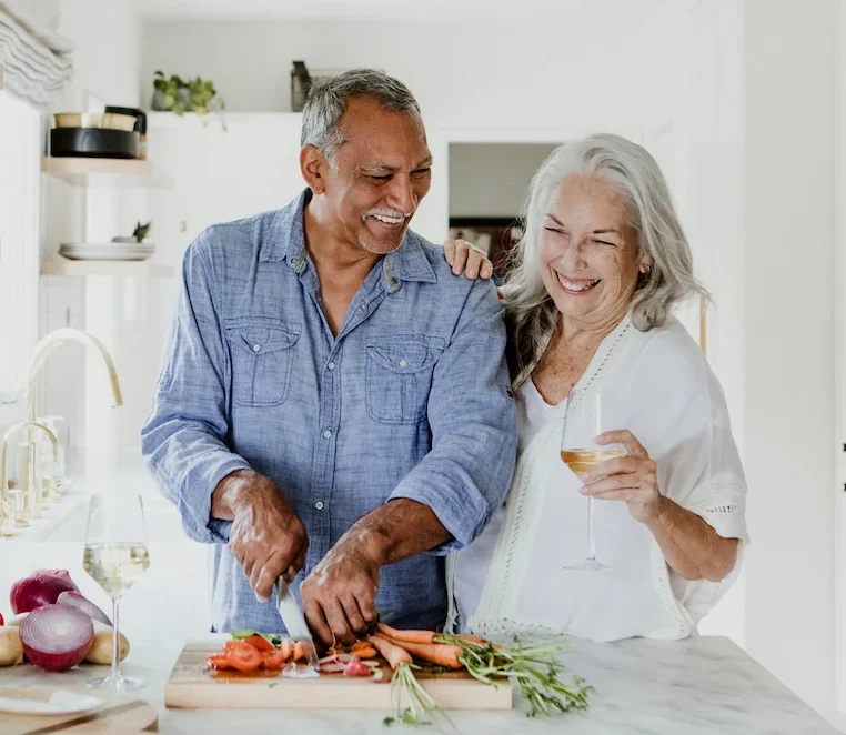 Senior couple chopping vegetables in kitchen