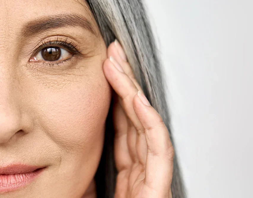mature asian woman touching smooth skin around eye area